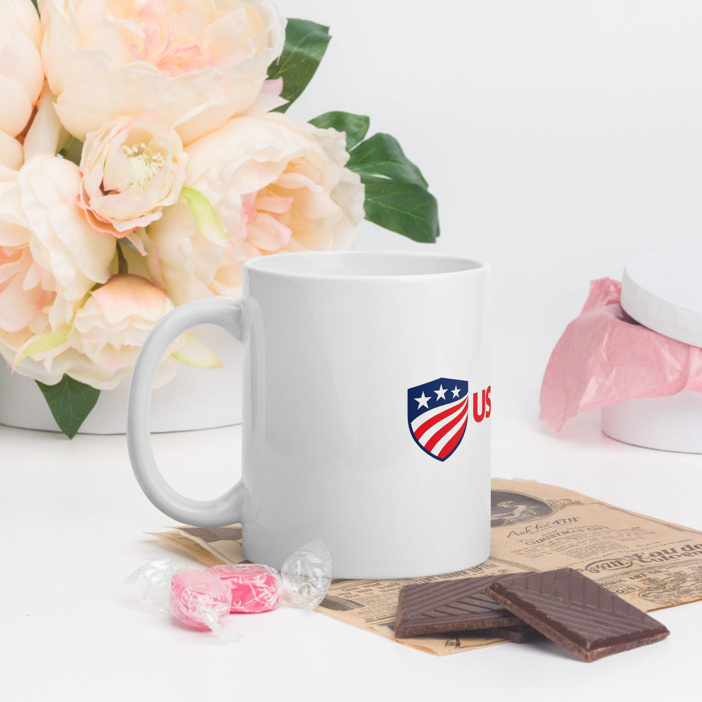 11 oz white glossy ceramic mug with the USAmerch shield logo, handle on the left