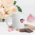 11 oz white glossy ceramic mug with the USAmerch shield logo, handle on the left